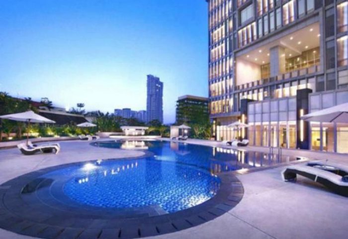 The Grove Suites by GRAND ASTON pool. Gay-friendly hotel with outdoor pool, lounge chairs, and city view. Luxury travel for gay men.