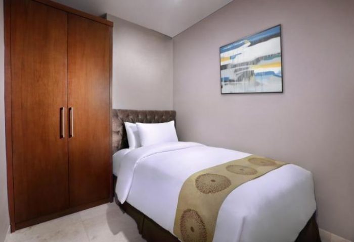 The Grove Suites by GRAND ASTON room. Gay-friendly hotel with a single bed, wardrobe, and modern art. Ideal for gay travel.