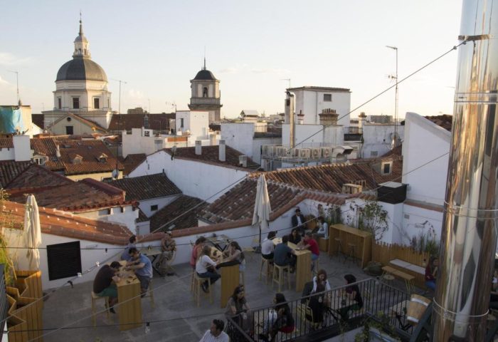 Rooftop view at The Hat Hostel, a gay-friendly hotel in Madrid. People socialize with city views. A great spot for gay travelers.