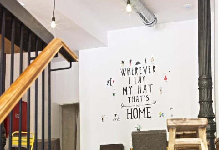 The Hat Hostel Madrid interior. Gay-friendly hotel with modern design. Wall art: Wherever I lay my hat, that's my home. Cool lighting.