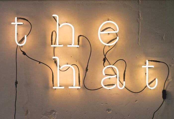 The Hat neon sign at The Hat Hostel, Madrid. A gay-friendly hotel, it's a cool spot for LGBTQ+ travelers visiting Madrid, Spain.