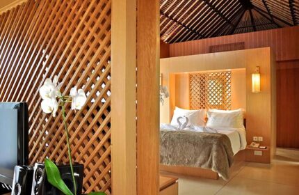 The Haven Bali Seminyak gay-friendly hotel room. A luxurious bed with swan towels, wood accents, and orchid. Ideal for gay travel.