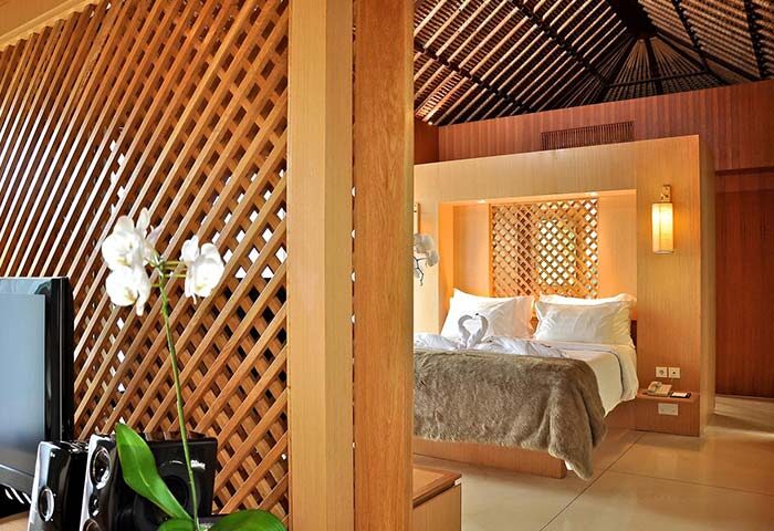 The Haven Bali Seminyak gay-friendly hotel room. A luxurious bed with swan towels, wood accents, and orchid. Ideal for gay travel.
