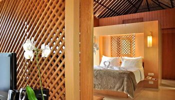 The Haven Bali Seminyak gay-friendly hotel room. A luxurious bed with swan towels, wood accents, and orchid. Ideal for gay travel.