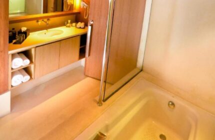 Bathroom at The Haven Bali Seminyak, a gay-friendly hotel. Bathtub, sink, and towels are visible. Gay travel to Seminyak, Bali.