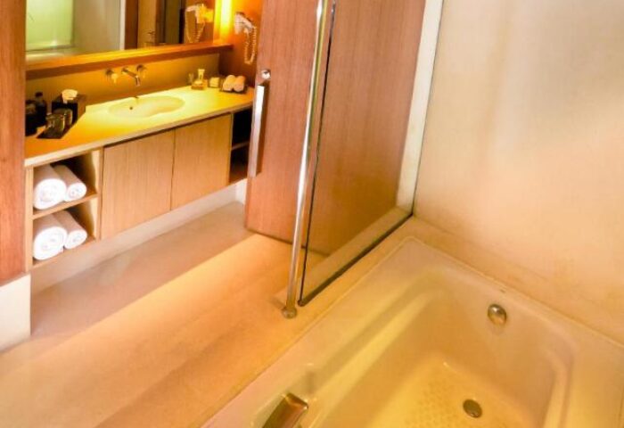 Bathroom at The Haven Bali Seminyak, a gay-friendly hotel. Bathtub, sink, and towels are visible. Gay travel to Seminyak, Bali.