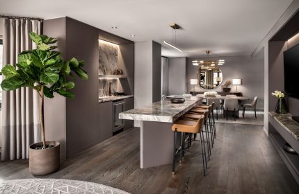 The Hazelton Hotel's gay-friendly suite: a marble counter with stools, a dining area, and a lush plant create a luxurious, welcoming space.