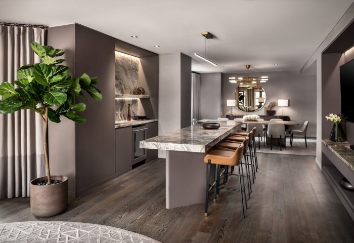 The Hazelton Hotel's gay-friendly suite: a marble counter with stools, a dining area, and a lush plant create a luxurious, welcoming space.