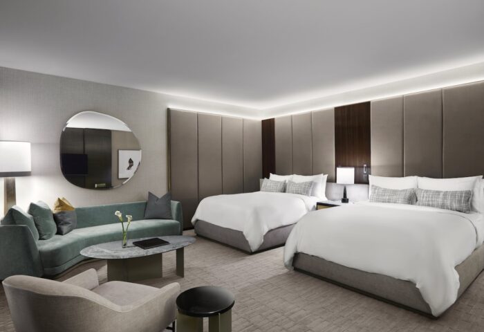 Gay-friendly The Hazelton Hotel room. Two beds, couch, and modern decor. Luxury travel for gay men. Upscale hotel room interior.