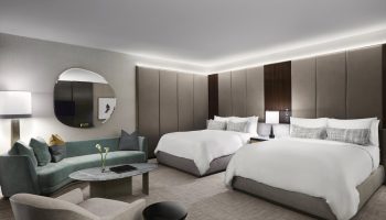 Gay-friendly The Hazelton Hotel room. Two beds, couch, and modern decor. Luxury travel for gay men. Upscale hotel room interior.