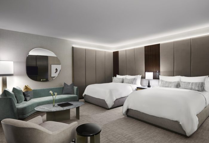 Gay-friendly The Hazelton Hotel room. Two beds, couch, and modern decor. Luxury travel for gay men. Upscale hotel room interior.