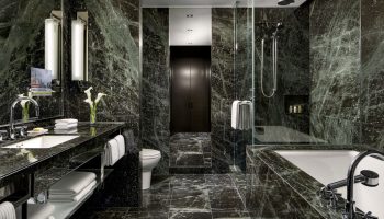 The Hazelton Hotel's luxurious bathroom. A gay-friendly hotel with marble walls, a soaking tub, and a walk-in shower. Upscale design for gay travelers.