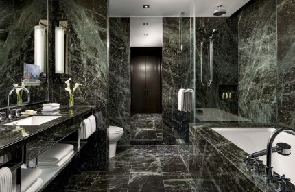 The Hazelton Hotel's luxurious bathroom. A gay-friendly hotel with marble walls, a soaking tub, and a walk-in shower. Upscale design for gay travelers.