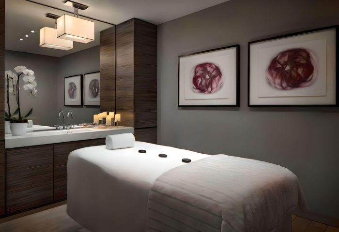 The Hazelton Hotel spa room with massage table, orchids, and artwork. A luxury, gay-friendly hotel for gay men travelers.