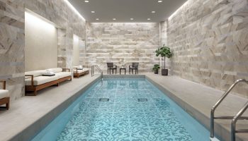 Indoor pool at The Hazelton Hotel, a gay-friendly hotel. The pool has a unique tile design. Chairs and lounges are nearby. Relaxing spa.
