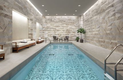 Indoor pool at The Hazelton Hotel, a gay-friendly hotel. The pool has a unique tile design. Chairs and lounges are nearby. Relaxing spa.
