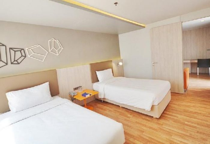 The Heritage Silom Hotel room with twin beds. Gay-friendly hotel in Bangkok, Thailand. Modern decor, clean white linens, and wooden floor.