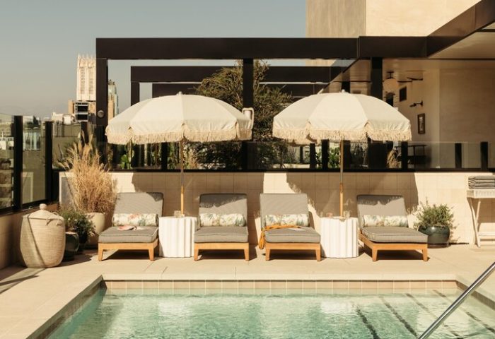 Poolside at The Hoxton Downtown LA, a gay-friendly hotel. Lounge chairs and umbrellas offer relaxation. Perfect for gay travel in Los Angeles.