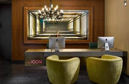 The Icon Hotel and Lounge reception area. Gay-friendly hotel features modern design, chandelier, and stylish seating.