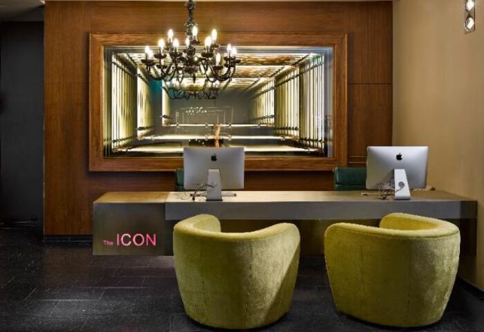The Icon Hotel and Lounge reception area. Gay-friendly hotel features modern design, chandelier, and stylish seating.