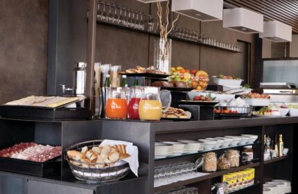 Breakfast buffet at The Independent Suites, a gay-friendly hotel. Features fresh juice, fruit, bread, meats, and pastries for a delicious morning meal.