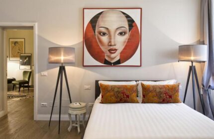Gay-Friendly Hotel The Independent Suites bedroom. Asian-inspired art above bed. Modern lamps, stylish decor. Gay travel lodging.