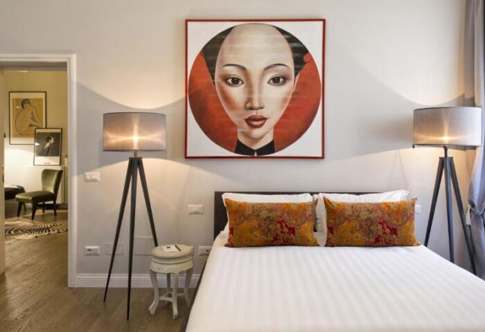 Gay-Friendly Hotel The Independent Suites bedroom. Asian-inspired art above bed. Modern lamps, stylish decor. Gay travel lodging.