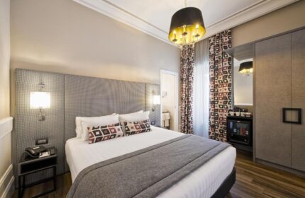 The Independent Suites' gay-friendly hotel room. Queen bed, patterned headboard, and stylish decor. Ideal for gay travelers seeking comfort.