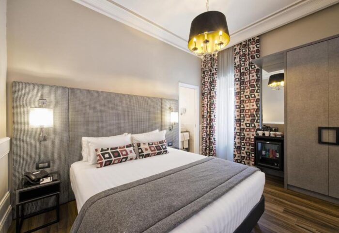 The Independent Suites' gay-friendly hotel room. Queen bed, patterned headboard, and stylish decor. Ideal for gay travelers seeking comfort.