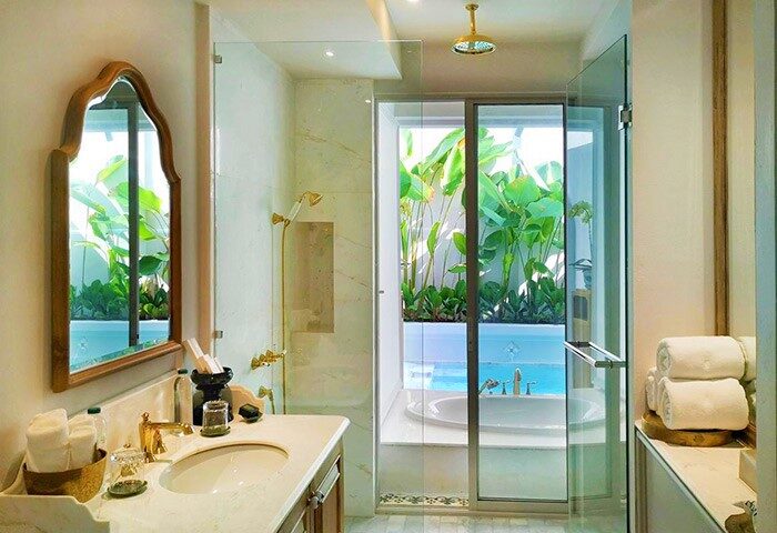 Bathroom at The Inside House, a gay-friendly hotel. Sink, mirror, shower with pool view. Luxury design for gay men's travel.