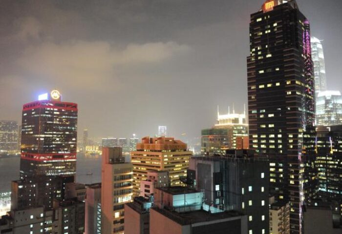 Night view of The Jervois, a gay-friendly hotel in Hong Kong. Features illuminated skyscrapers and city lights, ideal for gay travelers.