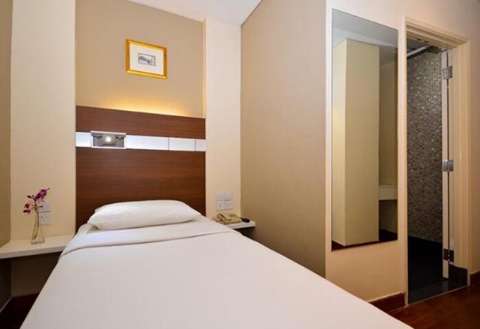 The Keong Saik Hotel room. Gay-friendly hotel with single bed, bathroom, and minimalist decor. Ideal for gay men travel in Singapore.