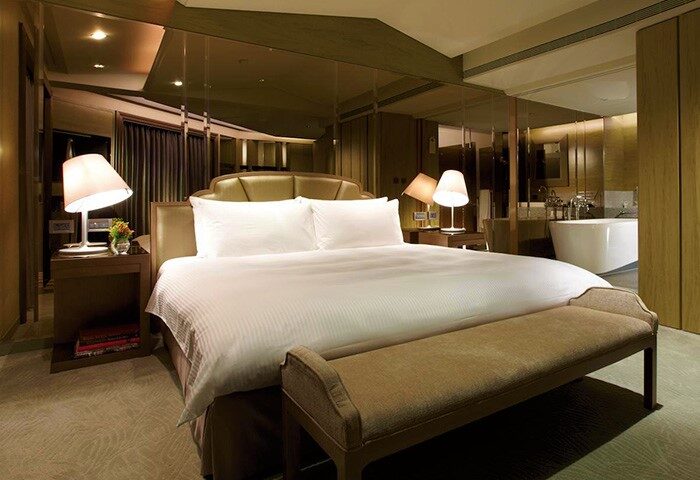 The Landis Taipei Hotel room. Gay-friendly hotel with a king-size bed, bench, and a luxurious bathroom with a soaking tub. Taipei gay travel.