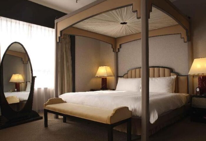 Gay-friendly The Landis Taipei Hotel room. Four-poster bed, bench, and mirror. Upscale lodging for gay travelers in Taipei.