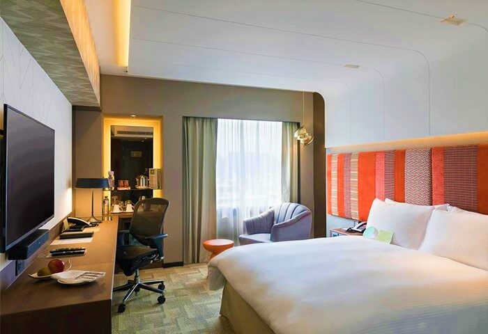 The Landis Taipei Hotel room. Gay-friendly hotel with bed, desk, TV, chair, and window. Modern design in Taipei, Taiwan. Comfortable stay.