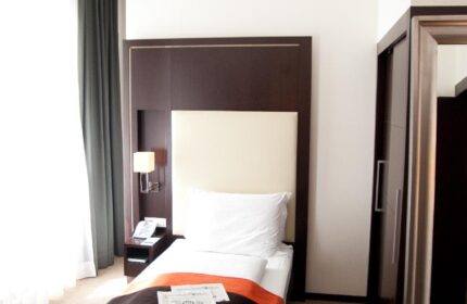 Levante Parliament Design Hotel Adults Only room. Single bed with dark brown headboard, bedside table, and window. Gay-friendly hotel.