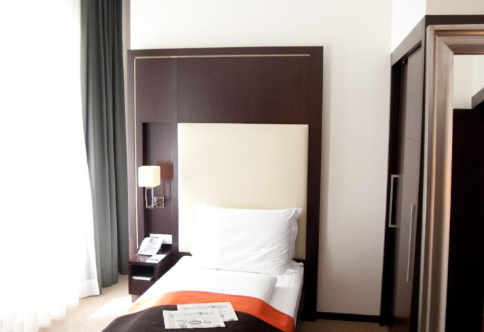 Levante Parliament Design Hotel Adults Only room. Single bed with dark brown headboard, bedside table, and window. Gay-friendly hotel.