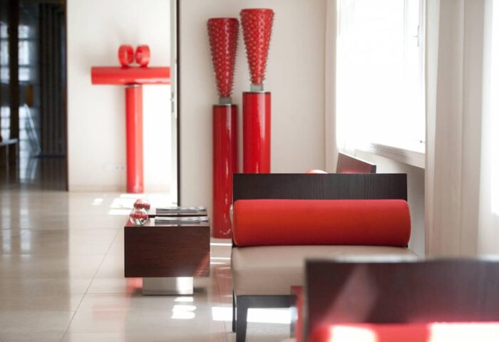 Lobby interior at The Levante Parliament, a gay-friendly design hotel. Adults-only space with red accents and modern furniture.