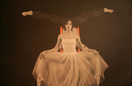 The Levante Parliament Design Hotel adult-only art: ballerina in tutu with man's legs above on orange chair. Gay-friendly hotel decor.