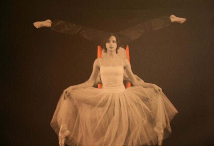 The Levante Parliament Design Hotel adult-only art: ballerina in tutu with man's legs above on orange chair. Gay-friendly hotel decor.