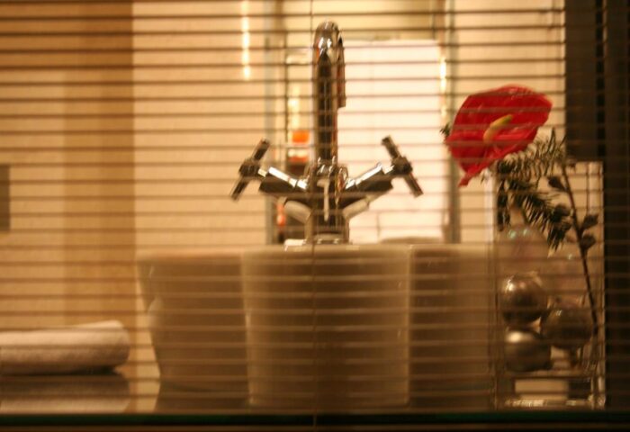 Bathroom detail at The Levante Parliament, a gay-friendly, adults-only design hotel. Faucet, flower, and blinds create a stylish ambiance.