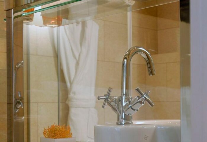 Bathroom detail at The Levante Parliament, a gay-friendly design hotel. Chrome faucet, white sink, and modern decor. Adults Only hotel.