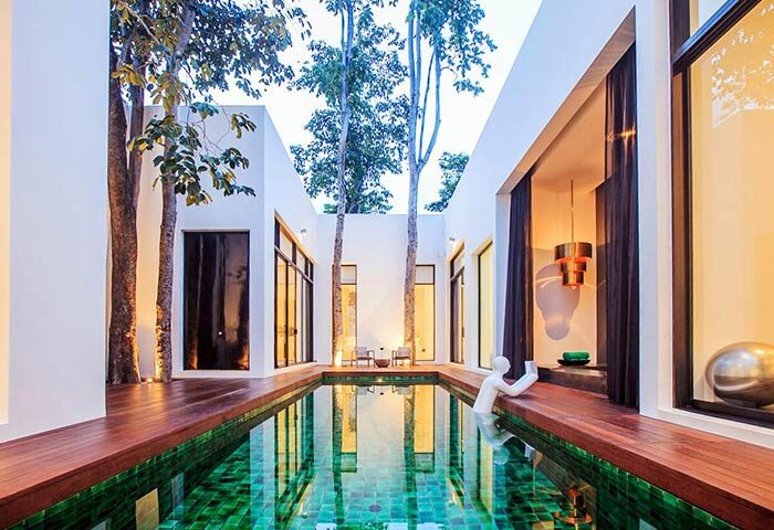 The Library Hotel pool. Gay-friendly hotel with modern design, green tiled pool, and trees. A unique, relaxing space for gay travelers.