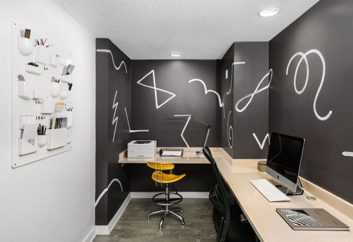 The Linq Hotel & Casino's workspace: Desk, computer, yellow chair, and wall art. A gay-friendly hotel with modern design elements.