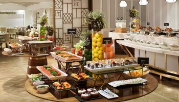 Buffet at The London West Hollywood at Beverly Hills, a gay-friendly hotel. Round tables display pastries, fruit, salmon, yogurt parfaits, and cheeses.