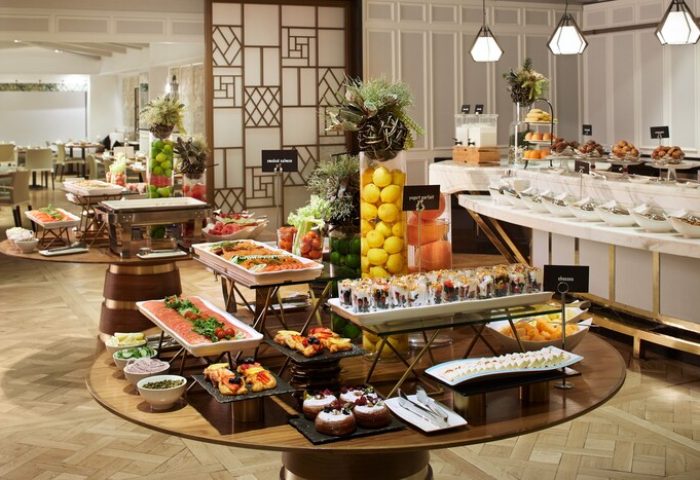 Buffet at The London West Hollywood at Beverly Hills, a gay-friendly hotel. Round tables display pastries, fruit, salmon, yogurt parfaits, and cheeses.