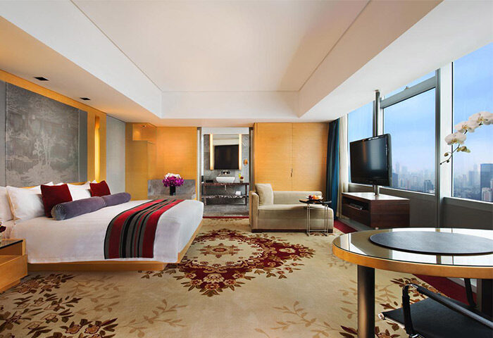 The Longemont Shanghai Hotel gay-friendly room. Luxury suite with king bed, city view, sofa, and bathroom. Upscale stay for gay travelers.