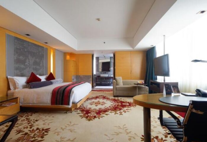 The Longemont Shanghai Hotel guest room. Gay-friendly hotel with a bed, desk, sofa, and bathroom. Luxury travel for gay men in Shanghai.