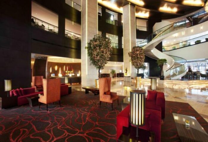 The Longemont Shanghai Hotel lobby. Gay-friendly hotel with modern design, seating areas, spiral staircase, and plants. Luxury travel for gay men.