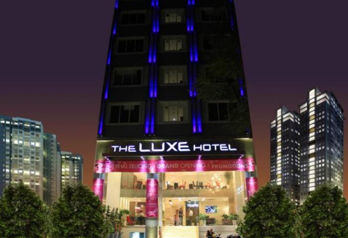 Exterior of The Luxe Hotel, a gay-friendly hotel. Modern building with blue lights. A great choice for gay men travelers.
